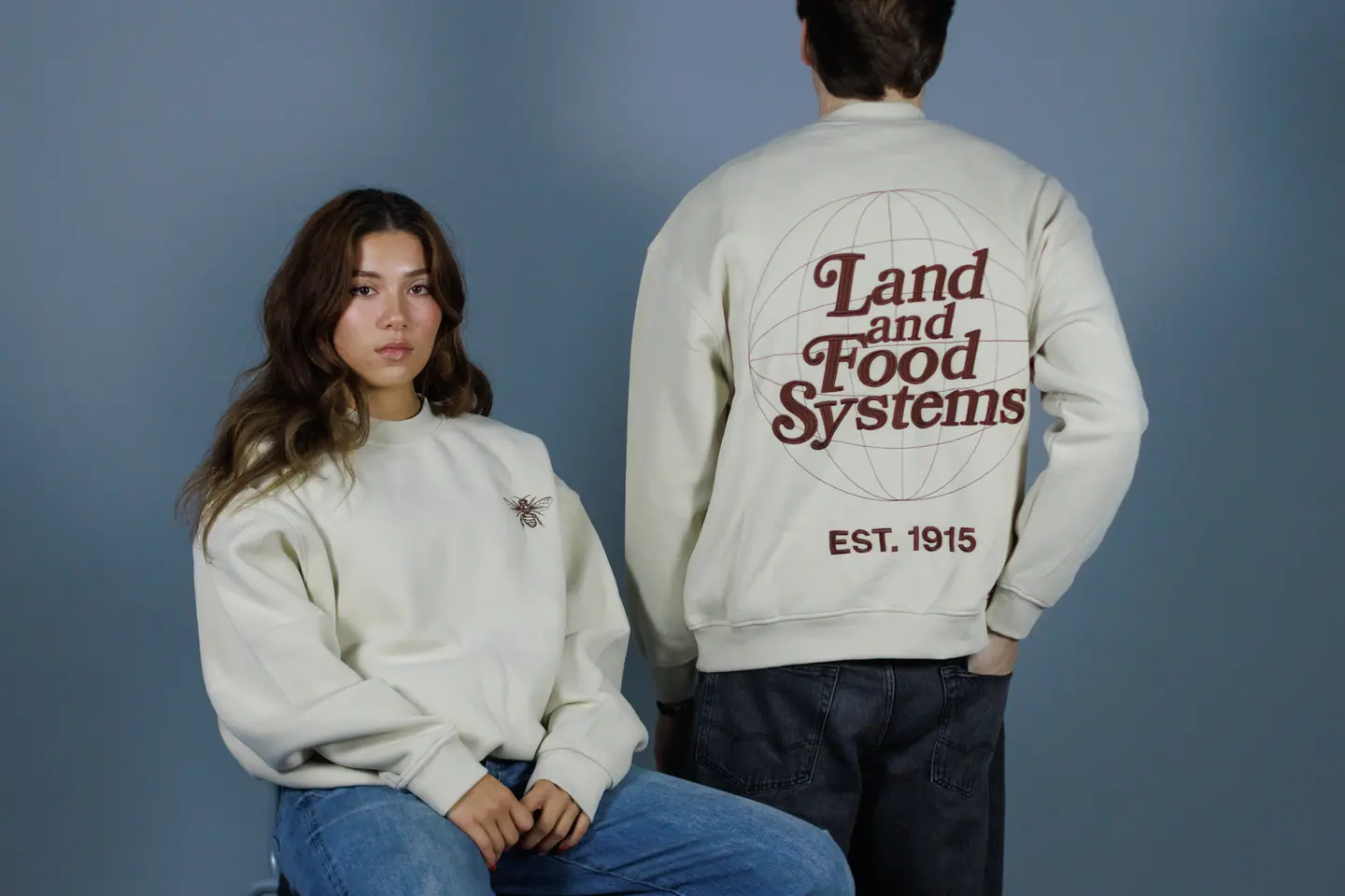 Two students in cream Land and Food Systems crewnecks, one from the front and one from the back